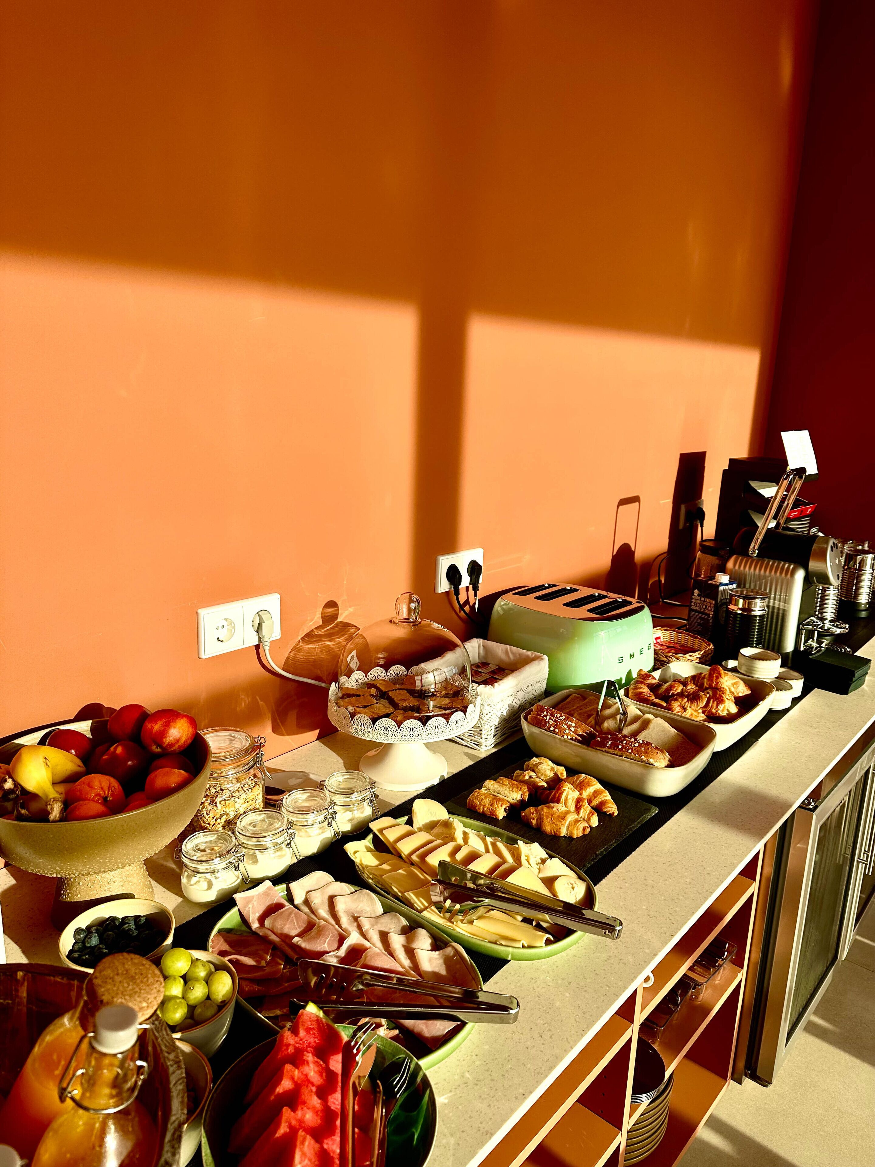 A buffet table with various food items and a coffee machine.