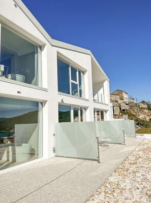 A modern building with large windows and a balcony. - Otantus Hotel (Muros)
