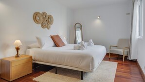 Une chambre bien rangée, avec un lit, une table de chevet et une chaise.