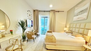 Habitación de hotel moderna con una cama grande, un escritorio con silla, televisión y vistas al exterior.