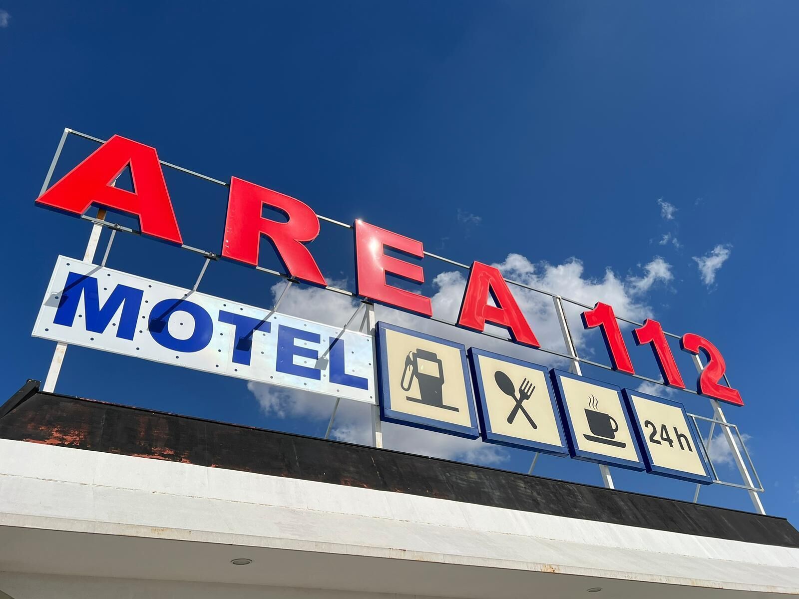 Señal de motel con el texto 'AREA 112' y 'MOTEL', que indica el nombre y la zona del motel.