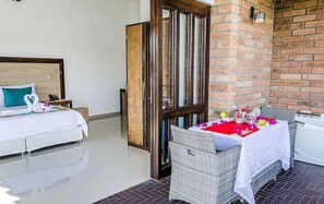 Relax in a stylish room with a large bed, nightstand, and dining area.