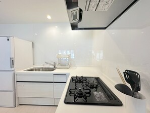 Kylskåp, mikrovågsugn, spishäll och grytor/köksredskap