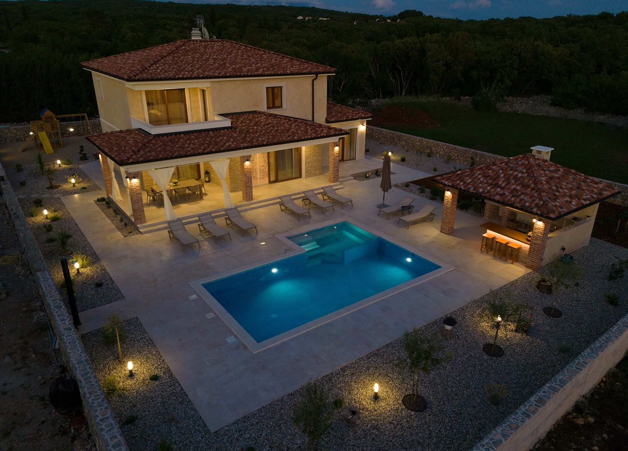 A two-story house with a swimming pool, outdoor seating, and a barbecue area.