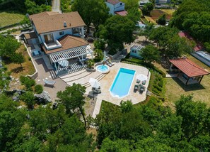 A large house with a swimming pool, outdoor seating, and a covered patio area. - Villa Laura with pool and jacuzzi (Kvarner - Brusići) (Brusići)