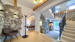 A spacious loft with exposed wooden beams, stone walls, a staircase with metal railings, and a cozy seating area. - Villa Laura with pool and jacuzzi (Kvarner - Brusići) (Brusići)