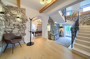 A spacious loft with exposed wooden beams, stone walls, a staircase with metal railings, and a cozy seating area. - Villa Laura with pool and jacuzzi (Kvarner - Brusići) (Brusići)