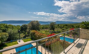 Ein Poolbereich mit Blick auf Berge und ein Gewässer.