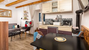 Un espacio habitable compacto con cocina, comedor y sofá.