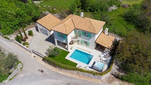 A two-story house with a swimming pool, surrounded by greenery and a stone wall. - Villa Luca with pool and jacuzzi (Kvarner - Vrh) (Vrh)