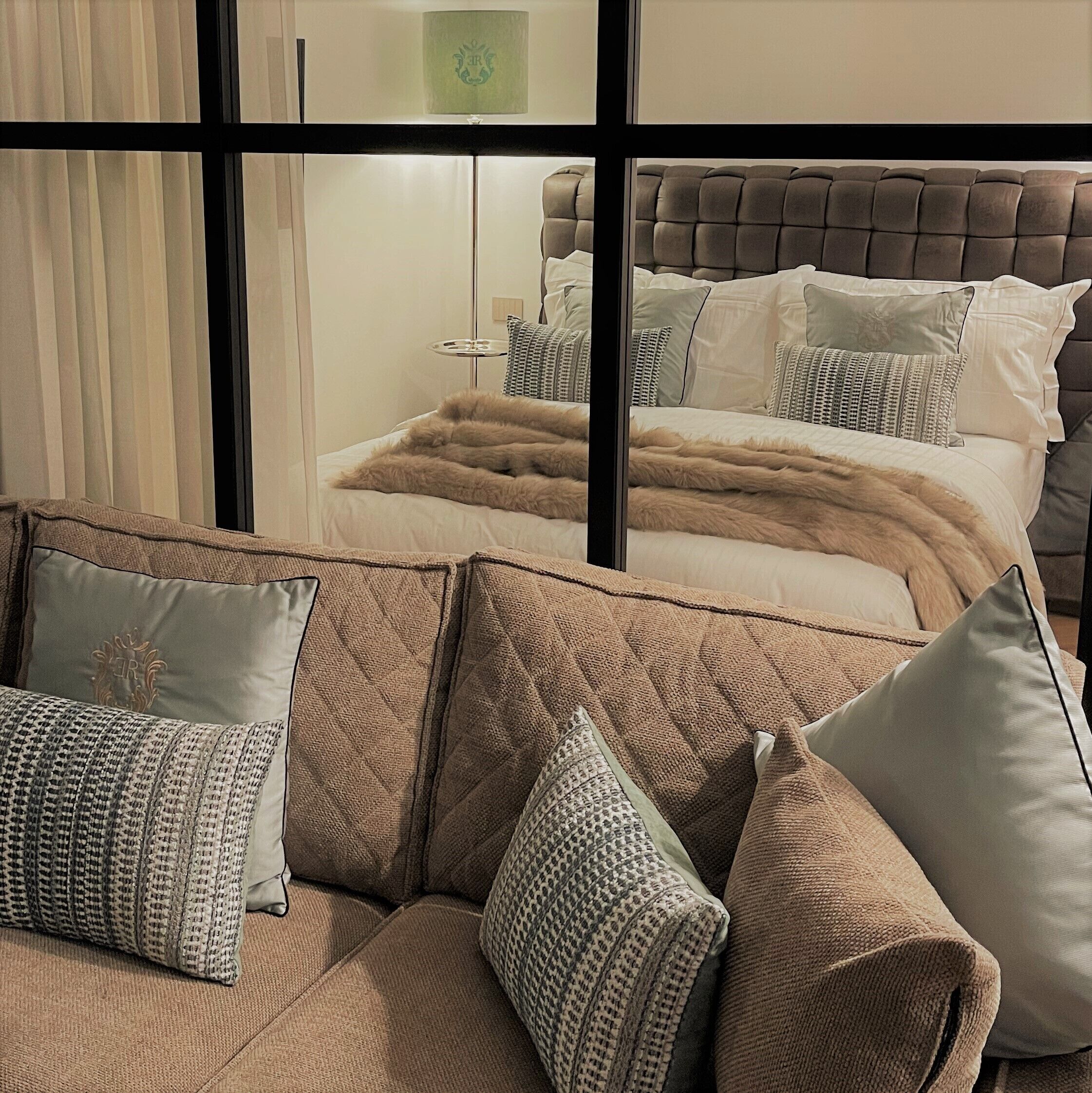Ein Schlafzimmer mit einem großen Bett, einem Schlafsofa und einem Fenster mit Vorhängen.