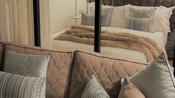 Ein Schlafzimmer mit einem großen Bett, einem Schlafsofa und einem Fenster mit Vorhängen.