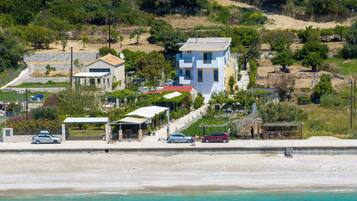 Situated on a sandy terrain, this coastal property offers a serene environment with a clear view of the adjacent beach.