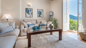A living room with a sofa, coffee table, and artwork on the wall.