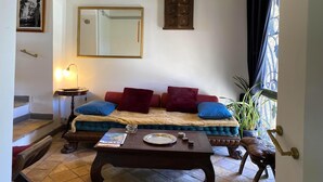 Un salon chaleureux avec un canapé, une table basse, un miroir et un escalier.
