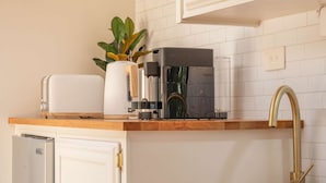 Eine Küche mit Kaffeemaschine, Toaster und einer Pflanze auf der Arbeitsfläche.