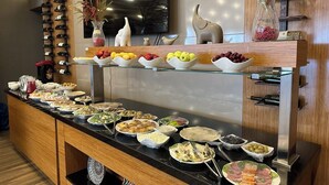 A buffet setup with various food items and a wine rack. - Hotel Bukhara (Bukhara)