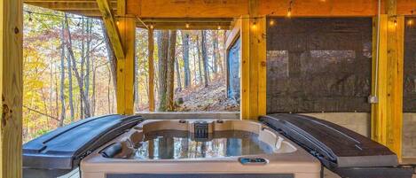 Una cabaña de madera con jacuzzi y caminadora.