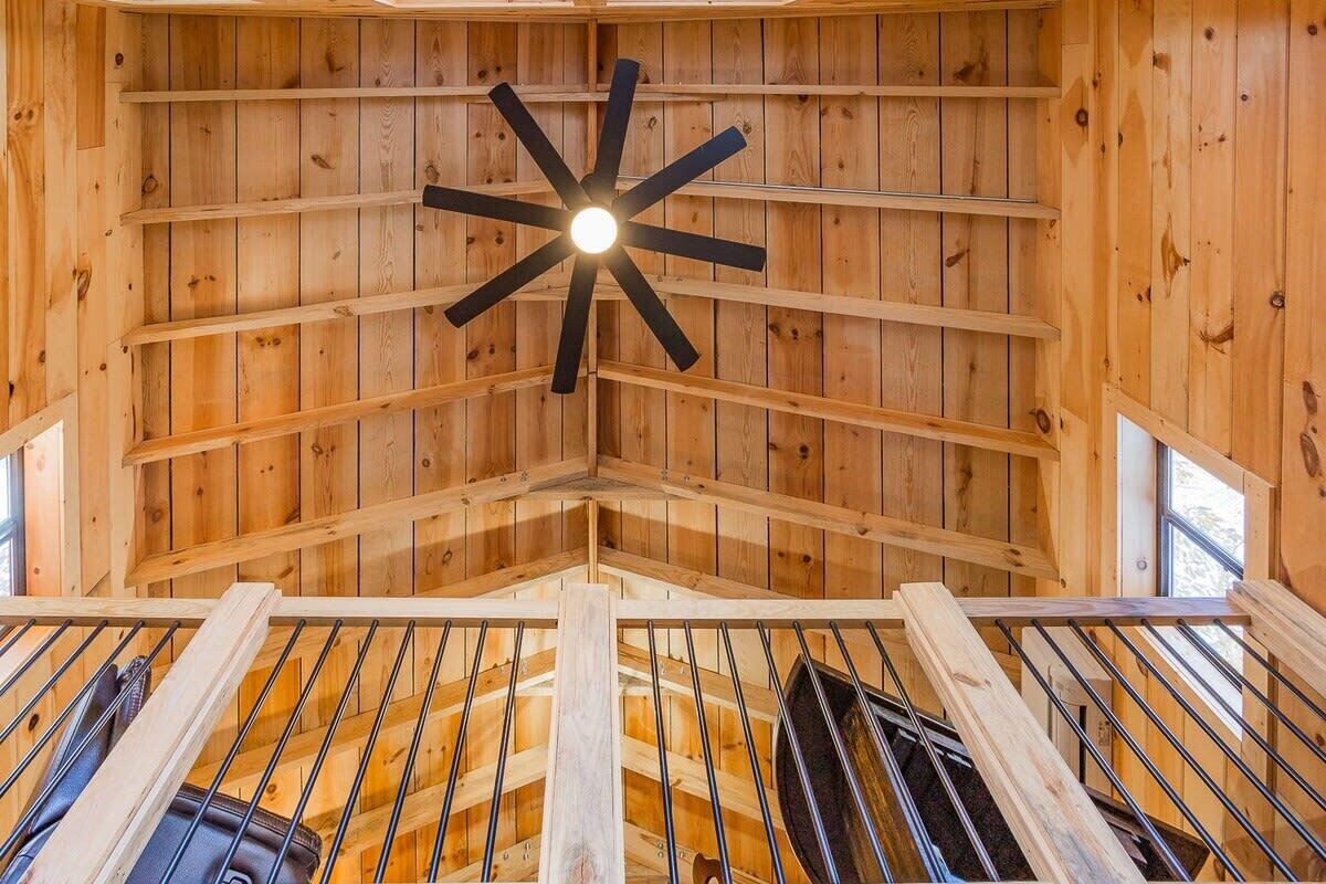 A wooden interior with a star-shaped ceiling light fixture and a spiral staircase.