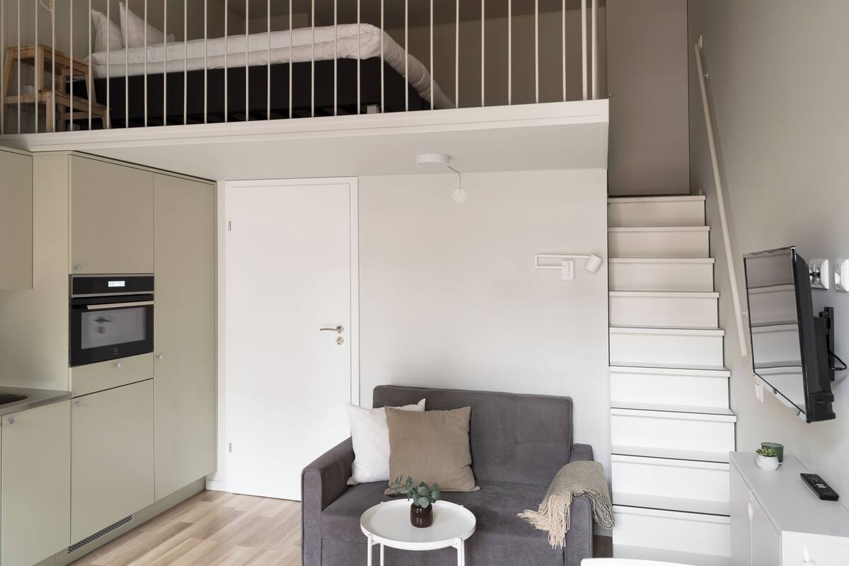 Un apartamento moderno con habitación estilo loft, comedor y cocina.