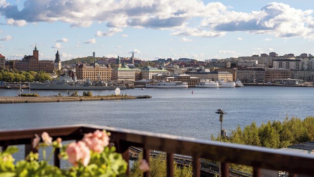 A waterfront cityscape with historic buildings, a large body of water, and a clear sky. - Waterfront Cabins Studio Apartments (Gothenburg)