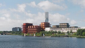 A waterfront view with modern buildings, including a tall skyscraper, and sailboats on the water. - Waterfront Cabins Studio Apartments (Gothenburg)