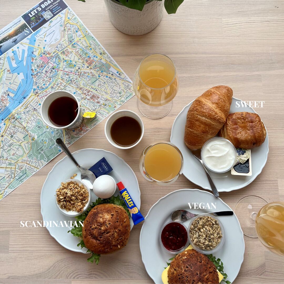 Una mesa con un mapa, café, croissants y opciones de comida vegana.