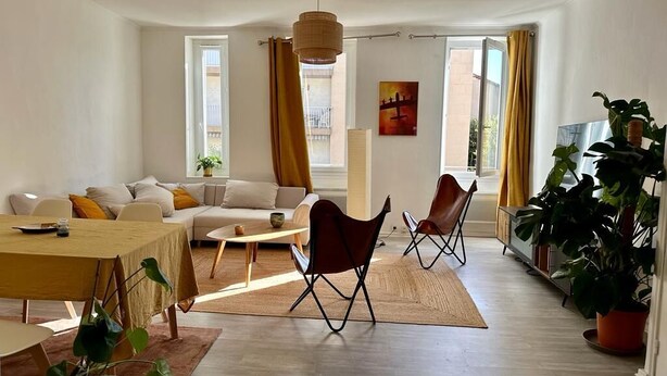 A modern living room with a sofa, chairs, a dining table, and large windows. - Grand 3 Pieces Lumineux, Lodi (Marseille)