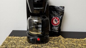 A coffee maker and a packet of ground coffee on a table. - The Heart of Wilton #5 (Wilton Manors)