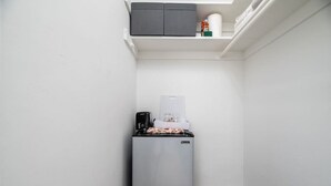 A compact kitchen with a refrigerator, coffee maker, and a small countertop. - The Heart of Wilton #5 (Wilton Manors)