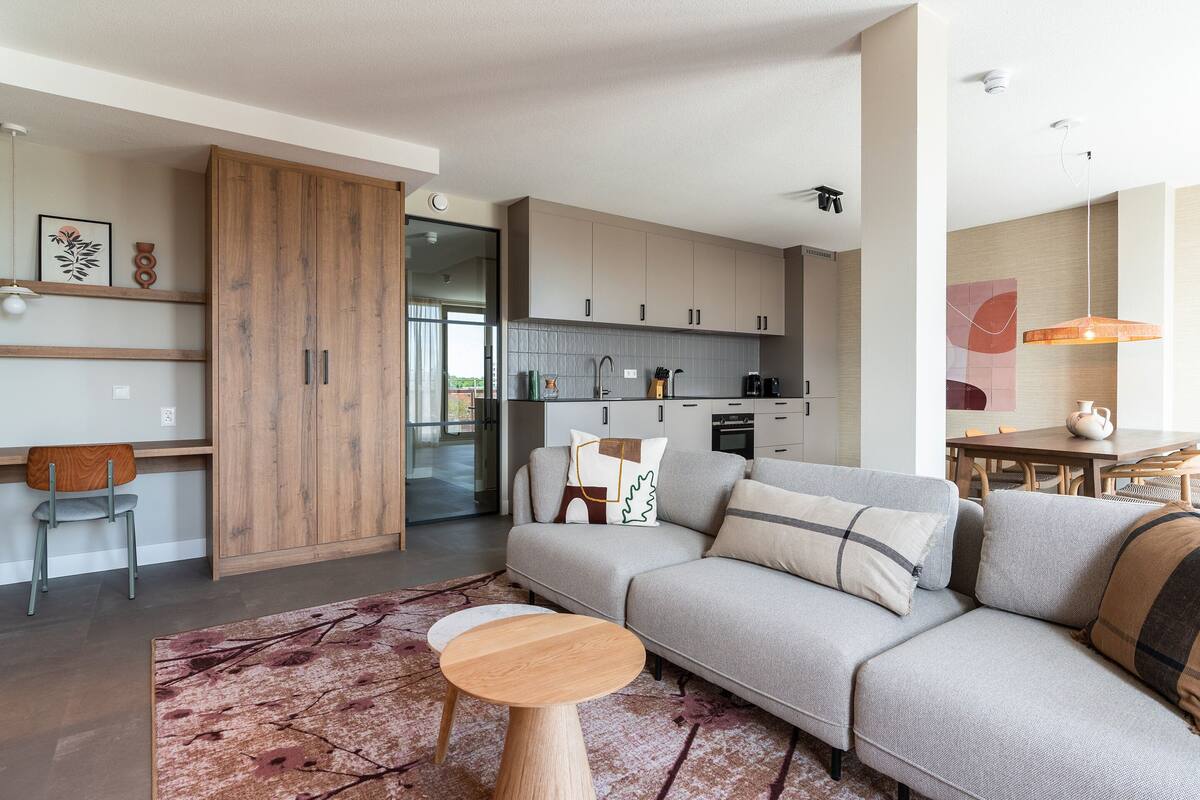 A modern living room with a grey sofa, wooden sideboard, and a coffee table.