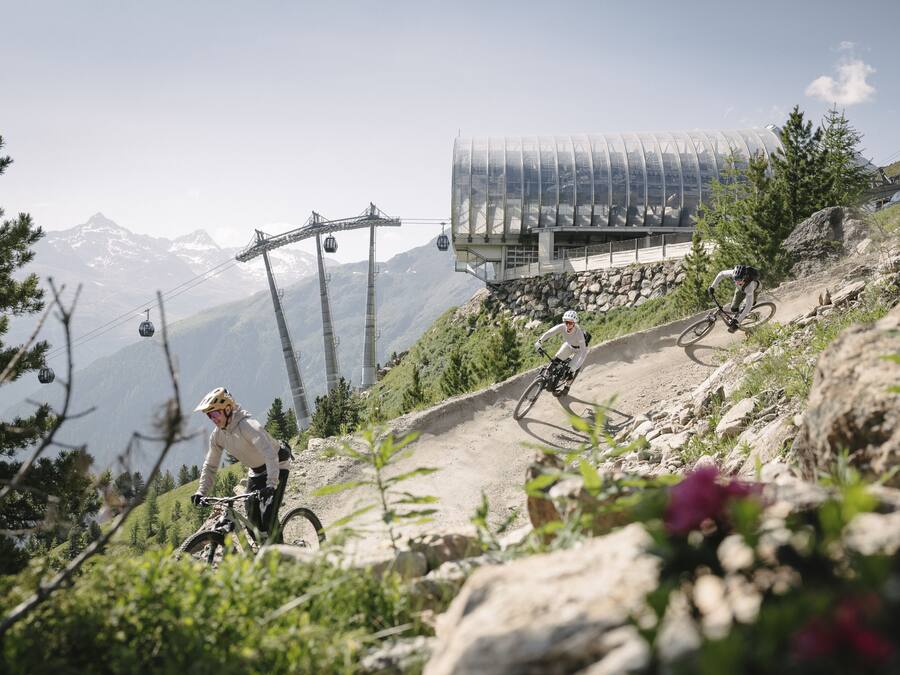 Een mountainbiketrail met een kabelbaan op de achtergrond.