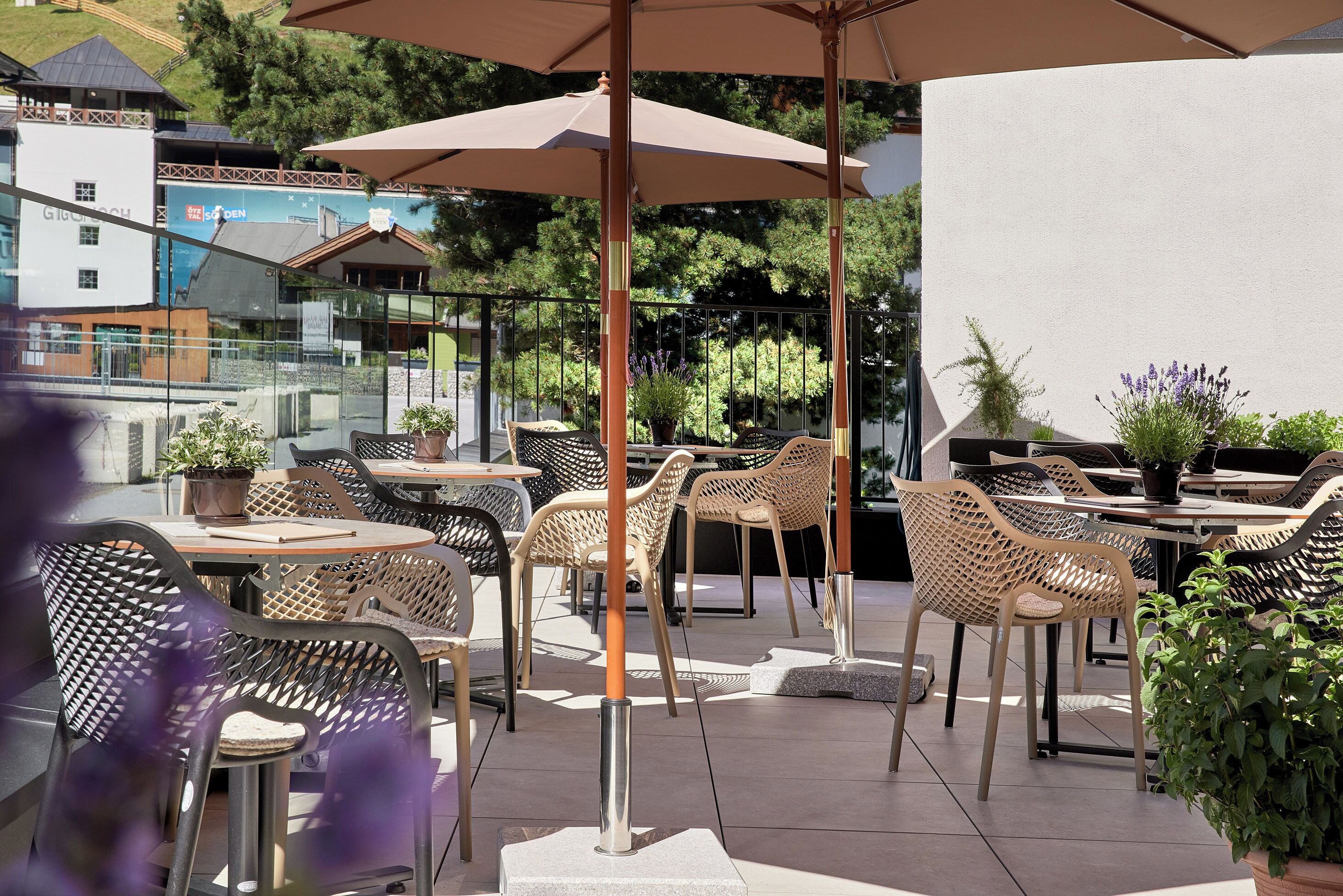 An outdoor seating area with wicker chairs, tables, and umbrellas.