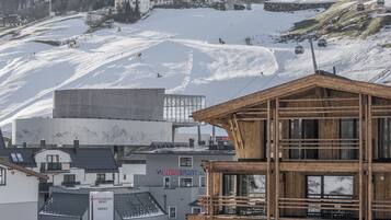 Une station de ski avec un bâtiment en bois portant l’inscription « INTERSPORT » et un panneau indiquant « SERVICE DE LOCATION INTERSPORT ».