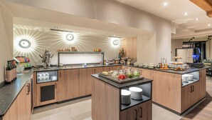 Una cocina moderna con una isla central, electrodomésticos integrados y una barra desayunadora.