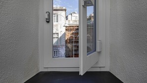 A door with a view of a building with classical architecture and scaffolding. - Raibetta Apartments by Wonderful Italy (Genoa)