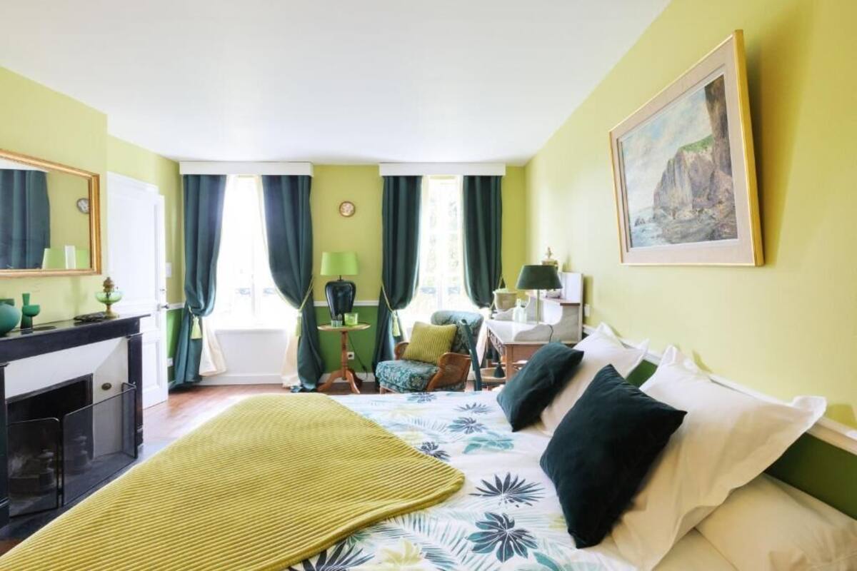 Ein Hotelzimmer mit Bett, Schreibtisch, Stuhl, Lampe und einem Bild an der Wand.