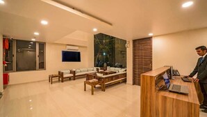 A modern hotel lobby with a reception desk, seating area, and large windows. - Crimson Park Residency & Spa (Udaipur)