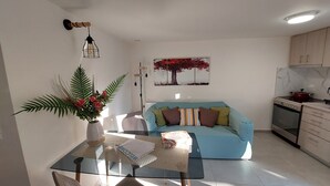 A modern living room with a sofa, a glass coffee table, and a decorative plant. - Cozy suite, by Spyros & Marina, near to the city centre & old venetian harbour  (Chania)