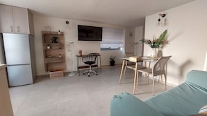 A compact living space with a kitchenette, a dining area with a table and chairs, a sofa, and a potted plant. - Cozy suite, by Spyros & Marina, near to the city centre & old venetian harbour  (Chania)