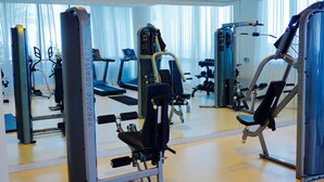 A gym with various exercise machines, a treadmill, and a mirrored wall. - Pet Friendly 2 Bedroom And Apartment Near Rittenhouse Apts by RedAwning (Philadelphia)
