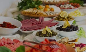 A variety of food items including sliced meats, olives, and fruits arranged on a table. - Volens Hotel - All inclusive (Gebze)