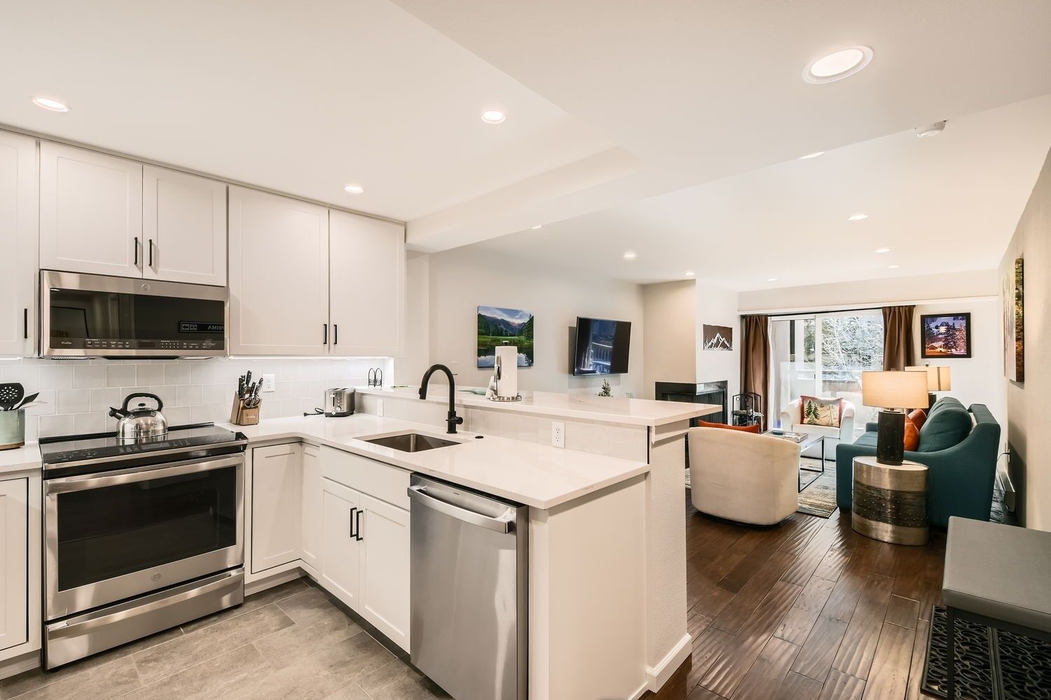 A modern kitchen with stainless steel appliances, a built-in dishwasher, and a large island with a sink.