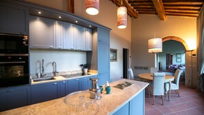 Una cocina moderna con armarios azules, electrodomésticos de acero inoxidable y encimera de mármol.