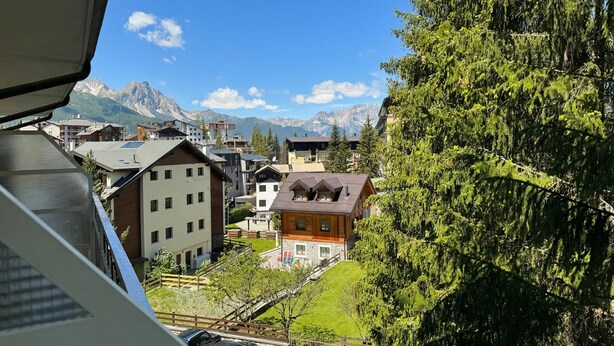 A residential area with buildings, a clear sky, and mountains in the background. - Studio Saturno 23 in the City Center (Sauze d'Oulx)