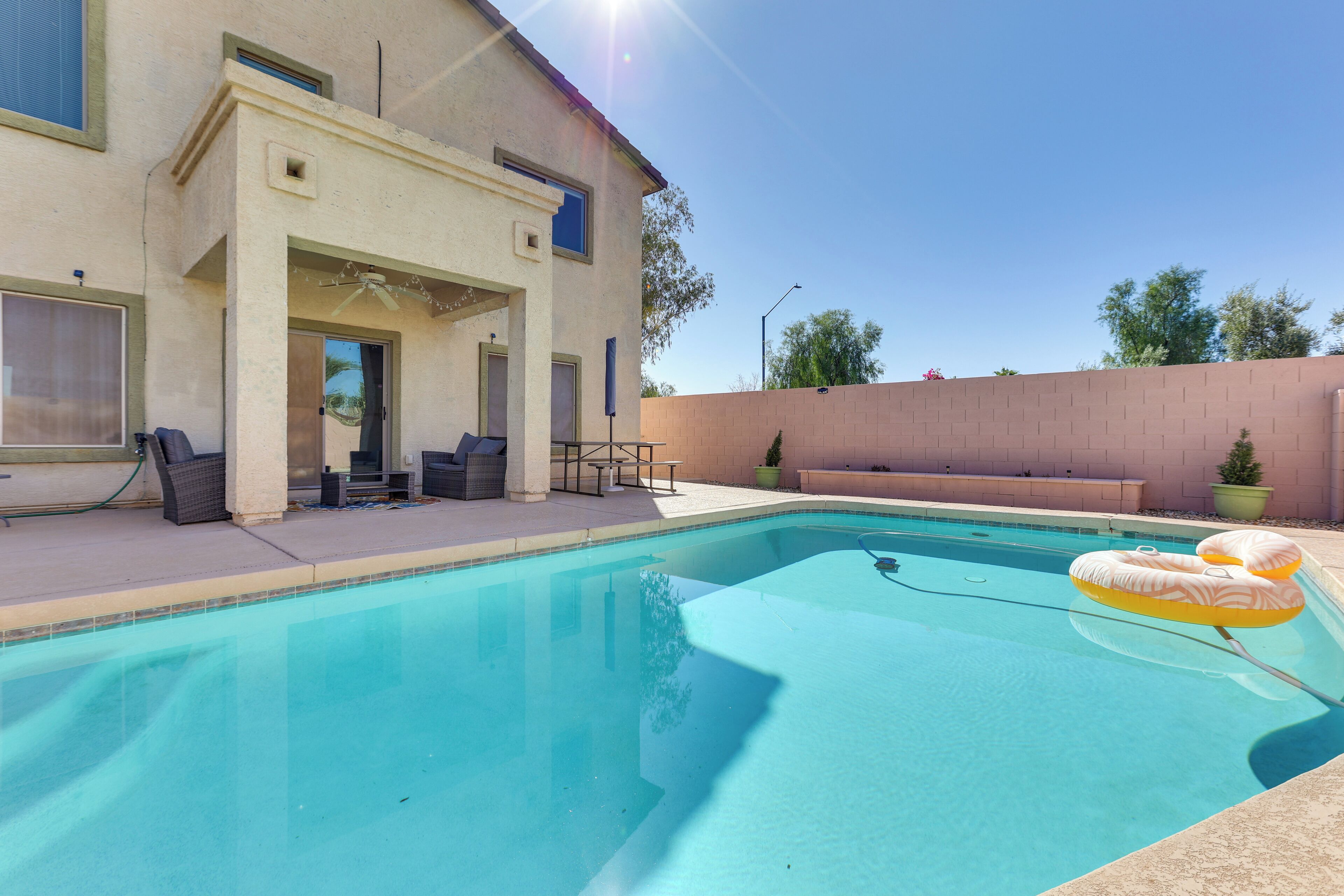 Ein Swimmingpool mit Liegestühlen und einem Tisch, umgeben von einem Gebäude mit Terrasse.