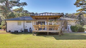 Une maison avec un belvédère en bois dans le jardin.