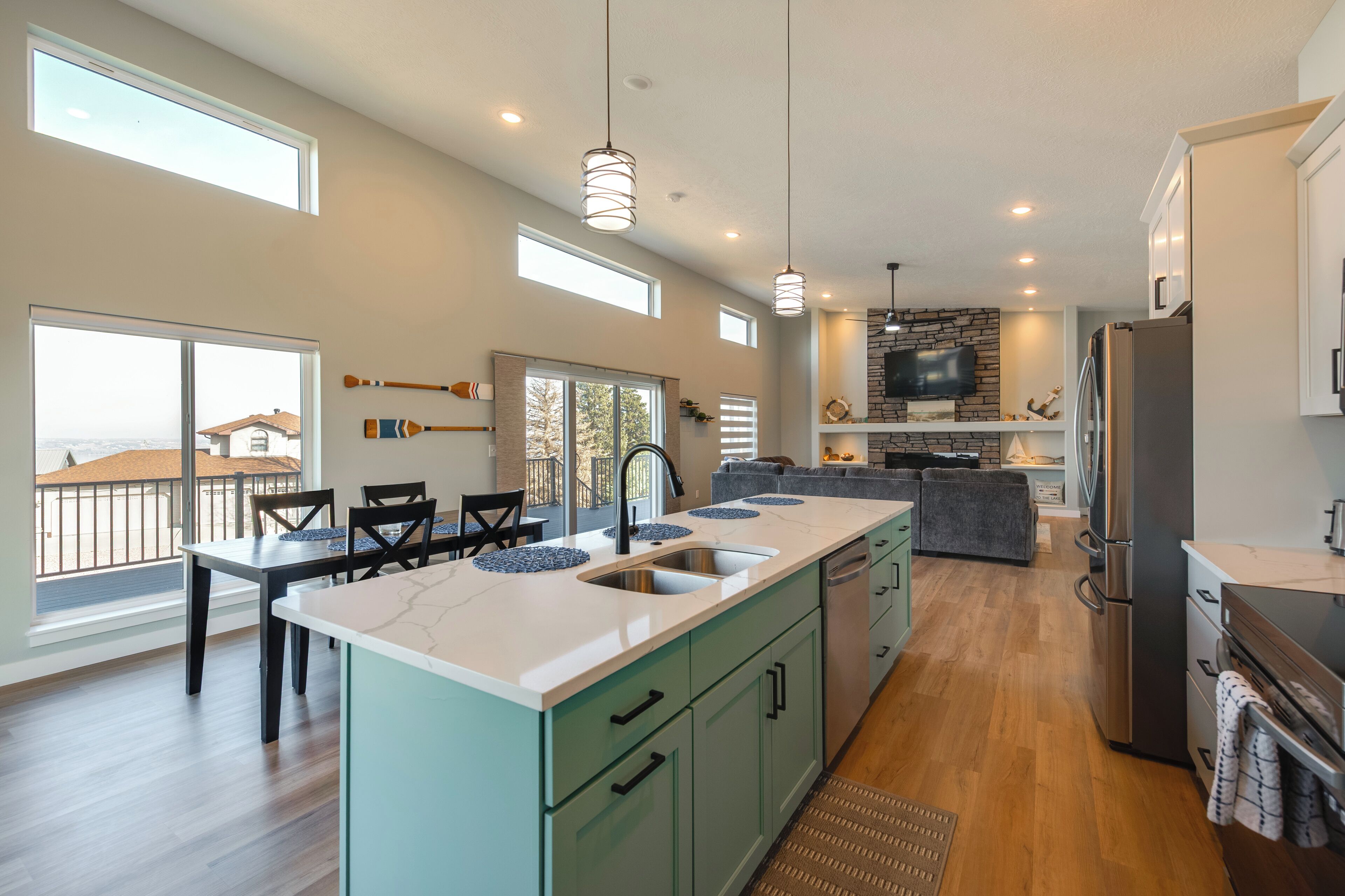 A modern kitchen with a large island, built-in appliances, and a dining area with a view.
