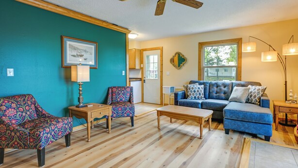 A living room with a blue sofa, patterned chairs, a wooden coffee table, and a wooden floor. - Charming Rockland Retreat w/ Deck & Grill! (Bangor)