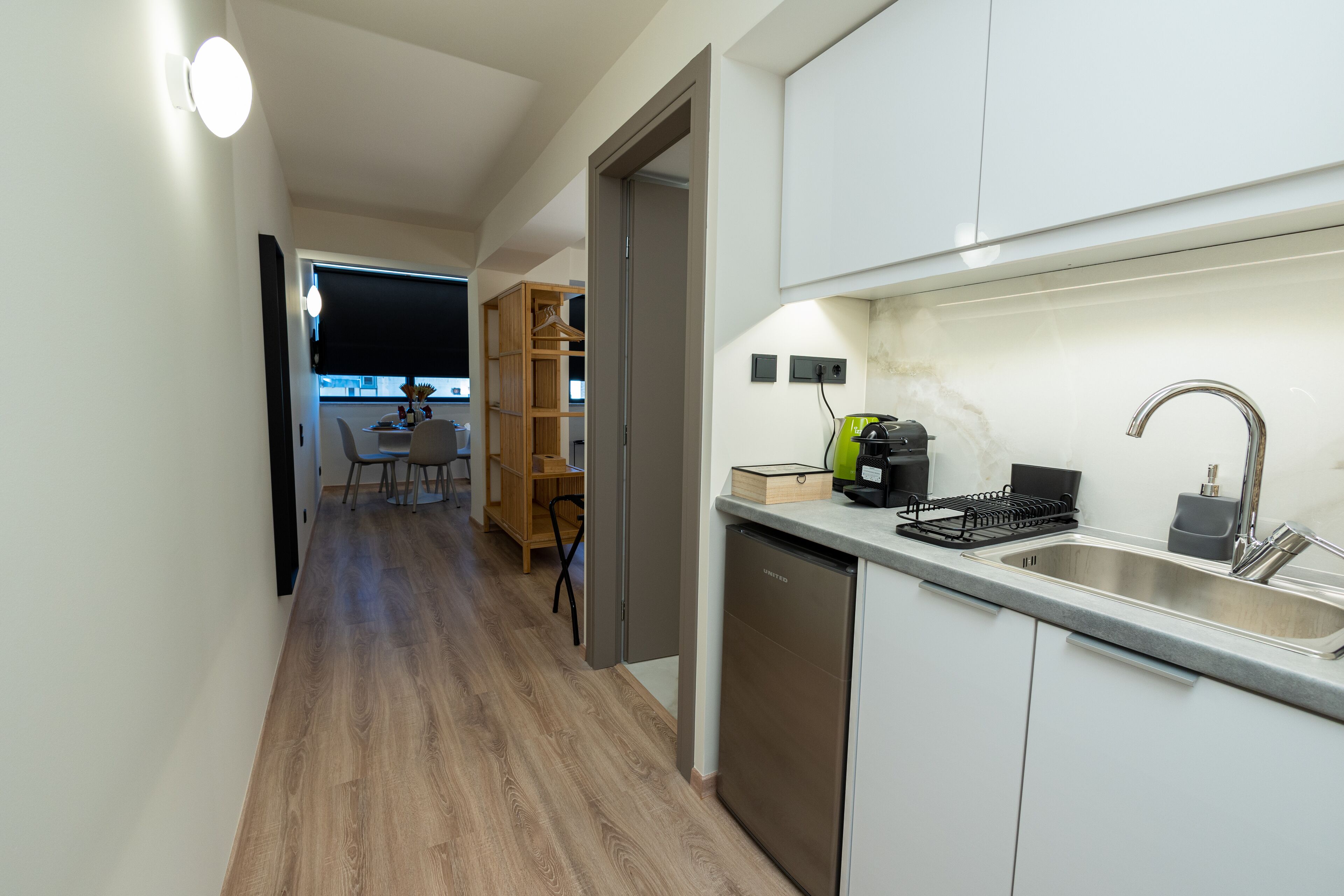 A modern kitchen with a stainless steel sink, a dishwasher, and a wooden cabinet.